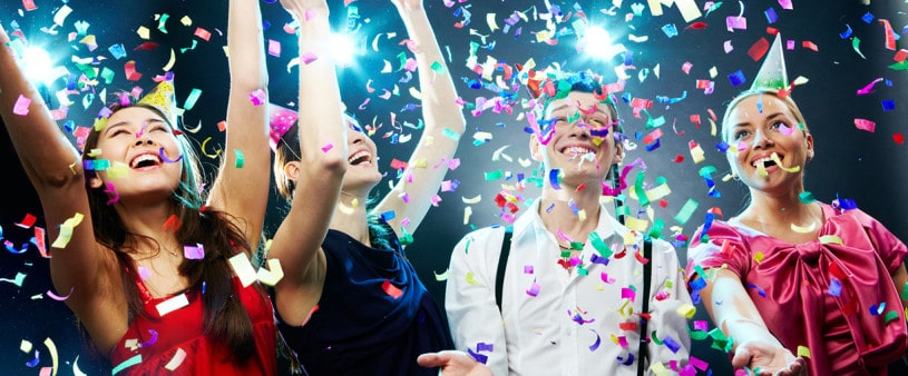 festive Four friends making having fun among confetti